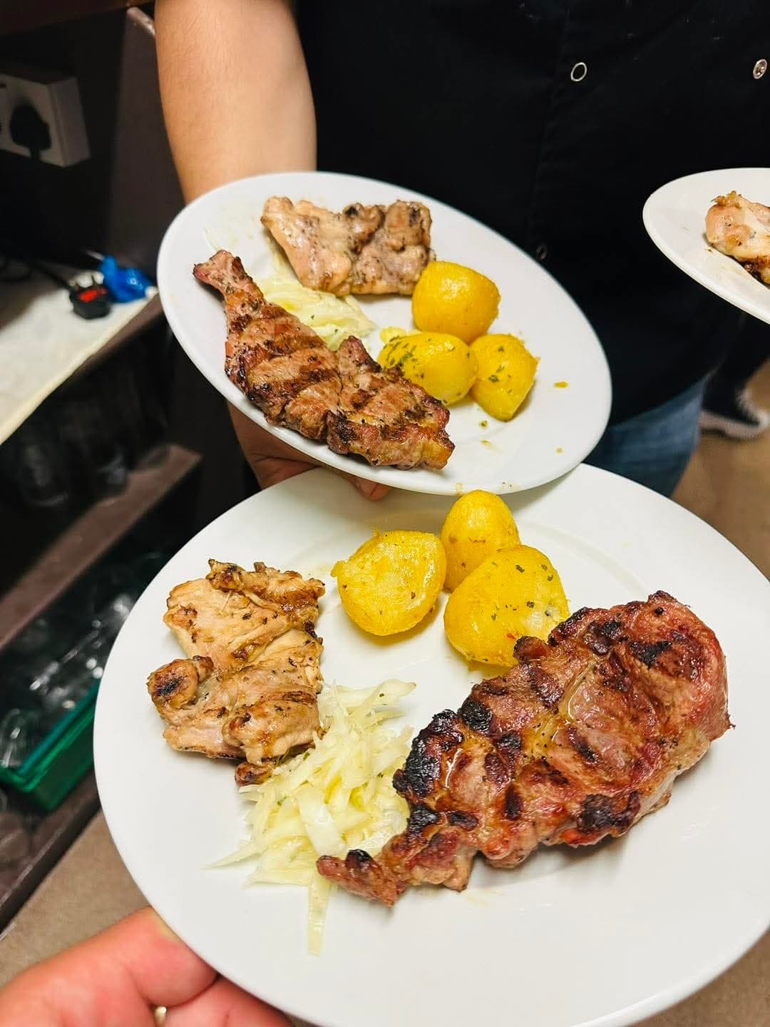 Grilled pork and chicken served with potatoes and coleslaw